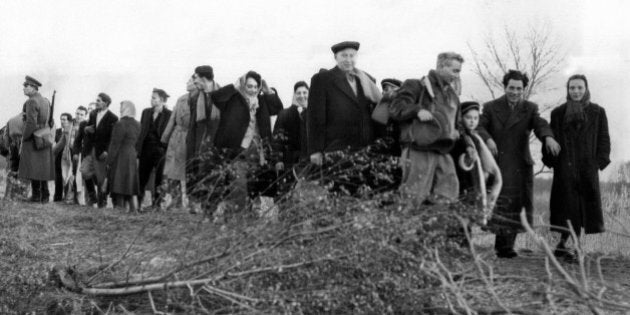 Despite all Russian attempts to plug the roads to freedom, Hungarians continually discover new points at which to cross the border to Austria. This happy-to-have-made-it group of men, women and children crossing the border at a point (âplease donât say whereâ) somewhere near the Neusiedler See in Austria Nov. 22, 1956. At left is an Austrian border guard (rifle). Partly hidden by the Austrian is a Hungarian border guard, who made no attempt to halt the refugees. The Hungarian border guards are armed with Russian submachineguns, but at some points these are used merely to fire a token and desultory burst high into the air. Hungarian refugees continue across the border. (AP Photo)