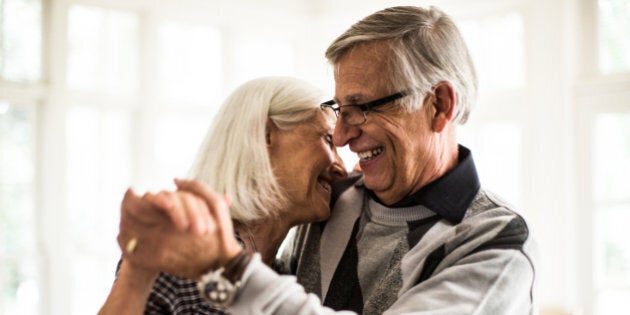 Senior couple dancing in living room