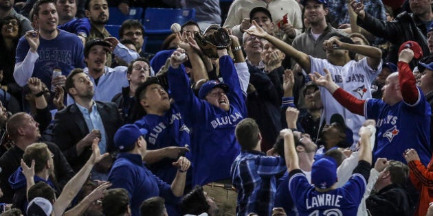 TORONTO, ON - APRIL 19 - Blue jays fans try for a foul ball along the first base line during the Toronto Blue Jays take on the New York Yankees at The Rogers Centre April 19, 2013. (David Cooper/Toronto Star via Getty Images)