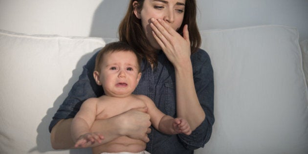 Tired mother holding crying baby