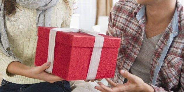 Woman handing husband Christmas gift