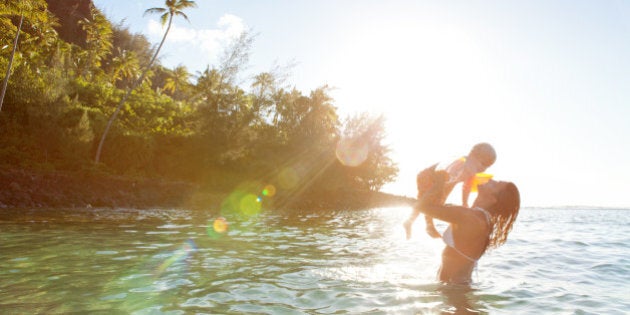 Mother and son having fun at tropical Kee Beach in Kauai, Hawaii, USA.