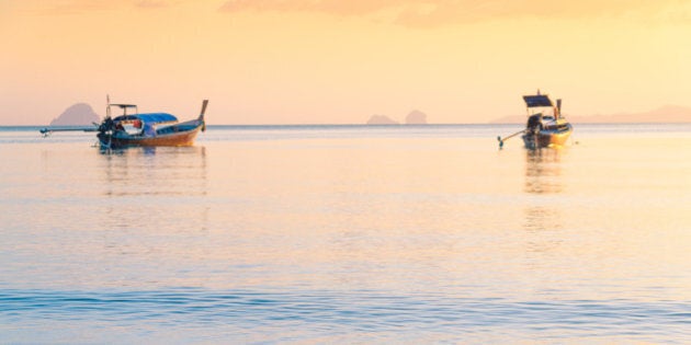 Beautiful sunset at tropical sea with long tail boat in south thailand