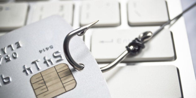 phishing - fish hook with a credit card on white computer keyboard