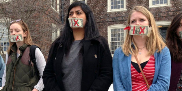 Brown University senior Maahika Srinivasan, center, of New Delhi, India, stands with senior Jeanette Sternberg Lamb, right, of Asheville, N.C., Wednesday, March 11, 2015, on the campus in Providence, R.I., where they organized a march to protest how the college handled recent sexual assault allegations. (AP Photo/Amy Anthony)