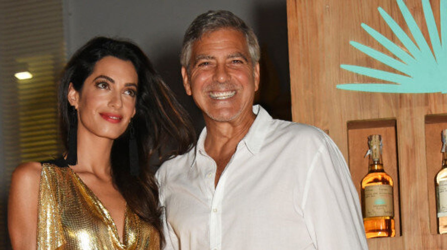 Amal Clooney dazzles in gold dress – and George can't take his