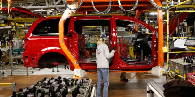 Fiat Chrysler assembly workers work on a partially assembled minivan at the Windsor Assembly Plant in Windsor, Ontario, February 9, 2015. The plant prepares to shut down for 14 weeks starting February 16 in preparation for Fiat Chrysler's next generation minivan. REUTERS/Rebecca Cook (CANADA - Tags: TRANSPORT BUSINESS)