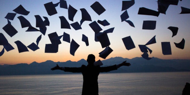 A young businessman throwing away his papers