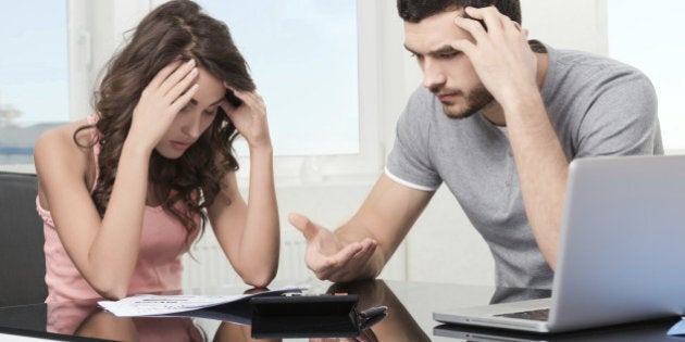 Couple, Man angry and upset after looking at credit card statement.