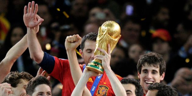 Spain's Andres Iniesta, center, holds up the World Cup trophy as he celebrates with fellow team members following the World Cup final soccer match between the Netherlands and Spain at Soccer City in Johannesburg, South Africa, Sunday, July 11, 2010. (AP Photo/Martin Meissner)