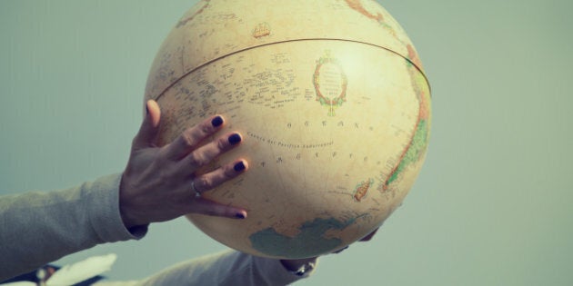 Hands holding a globe. Vintage tone effect.