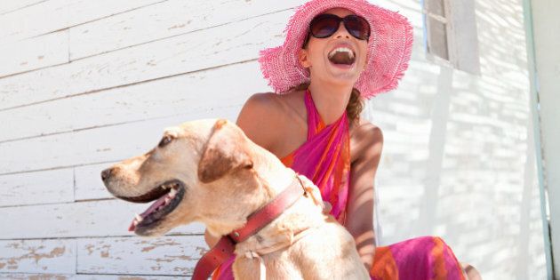 Laughing woman petting dog on patio