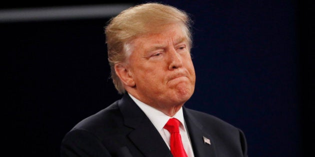 Republican U.S. presidential nominee Donald Trump listens as Democratic U.S. presidential nominee Hillary Clinton speaks during their presidential town hall debate with at Washington University in St. Louis, Missouri, U.S., October 9, 2016. REUTERS/Shannon Stapleton