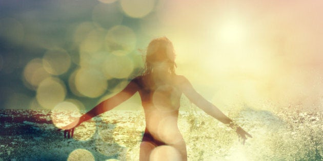 Beautiful Woman Standing in the Sea Waves and Enjoying Sunshine with Open Arms. Double Exposure Filtered Photo with Bokeh.