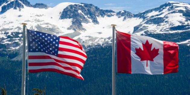 Canadian and American flags in the mountains