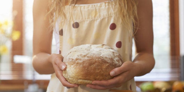 Woman holding freshly baked bread.