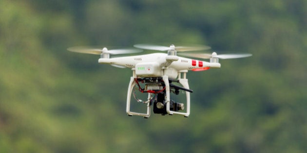 Drone with camera flying through nature.