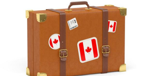 Travel suitcase with flag of canada isolated on white