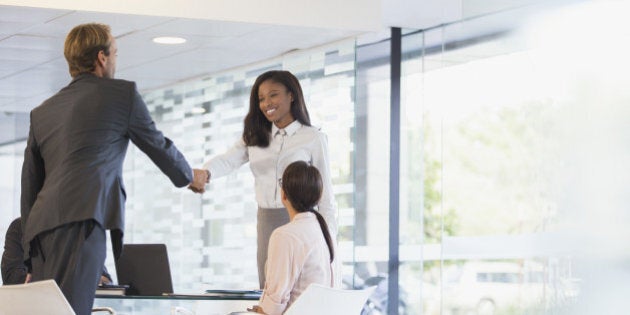 Business people shaking hands in office building