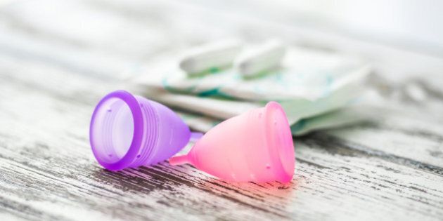 Different types of feminine hygiene products - menstrual cups, sanitary pads and tampons. Selective focus and shallow DOF