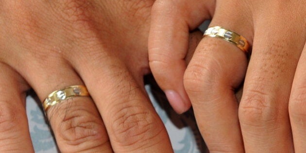 A couple holds hands showing their wedding rings during a mass wedding of 250 couple in Manila on October 10, 2010. The date 10/10/10 sparked a wedding frenzy, a wildly popular day to get married for couples who are superstitious, honoring their culture or just wanting a really cool anniversary date. AFP PHOTO / JAY DIRECTO (Photo credit should read JAY DIRECTO/AFP/Getty Images)