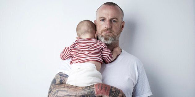 Father Holding Child In Arms. Studio, Family, Tattoos, Pride.