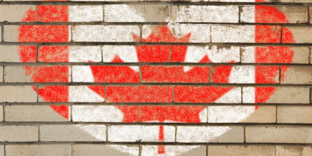 heart shaped flag in colors of Canada on brick wall