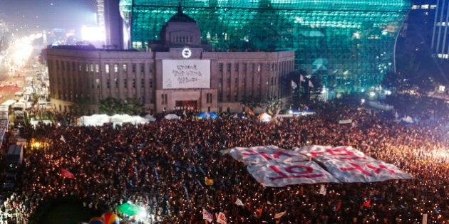 People hold a large banner, which reads,