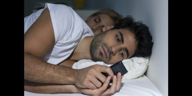 Man texting his mistress while wife is sleeping.