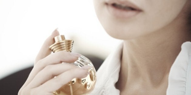 Woman applying and testing perfume