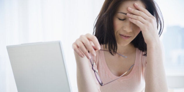 Frustrated Caucasian woman using laptop