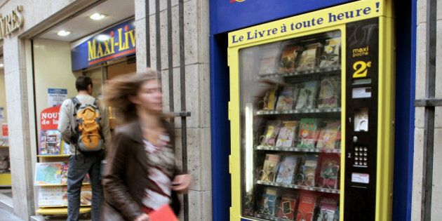 A passer-by runs past a book vending machine in a street of Paris, Friday, Aug. 19, 2005. Parisians craving Homer, Baudelaire or Maupassant in the middle of the night can get a quick literary fix at one of the French capital's five newly-installed book vending machines. Headline on the machine reads: