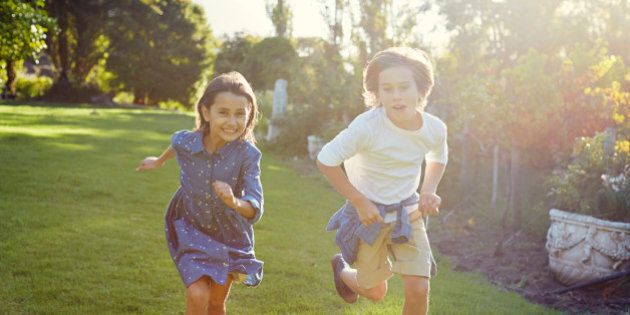 Two young children running in garden