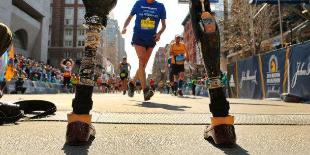 BOSTON - APRIL 18: Boston Marathon bombing survivor Celeste Corcoran stands on the finish line as she waits for runners in her running group, 50 Legs, to cross the finish line of the 120th Boston Marathon on Monday, April 18, 2016. Celeste lost both legs in the 2013 marathon bombing. Officials let her stand there to watch the runners. (Photo by John Tlumacki/The Boston Globe via Getty Images)