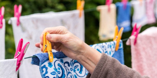 Old woman hanging laundry outdoor