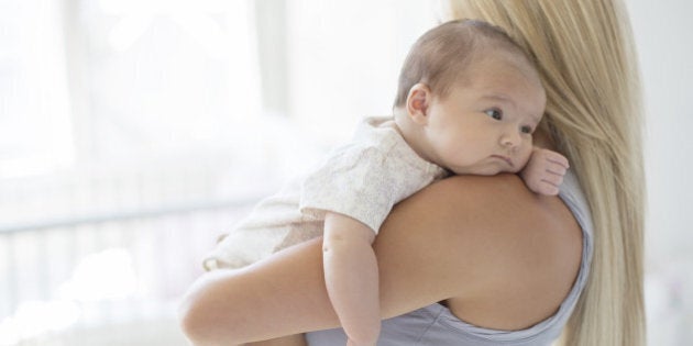 Mother holding baby girl in nursery