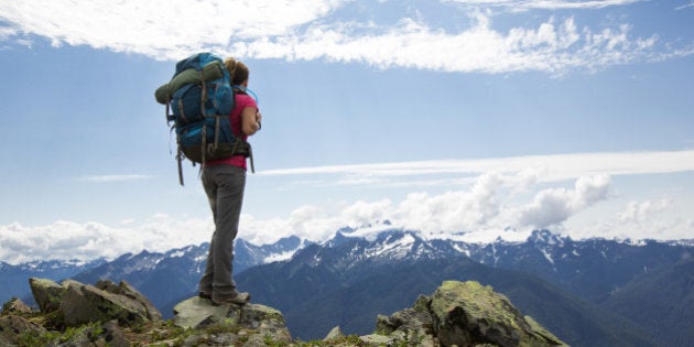 A female backpacking along a trail in the Olympic National Park.