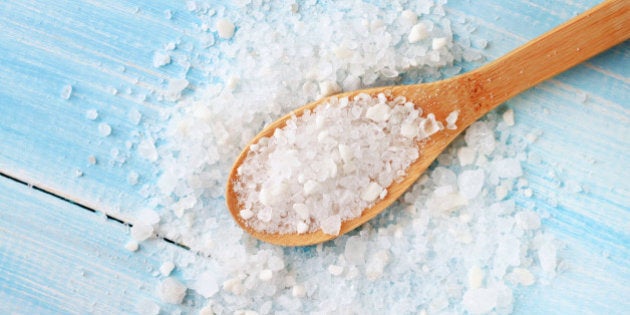 large grains of sea salt on shabby light blue table