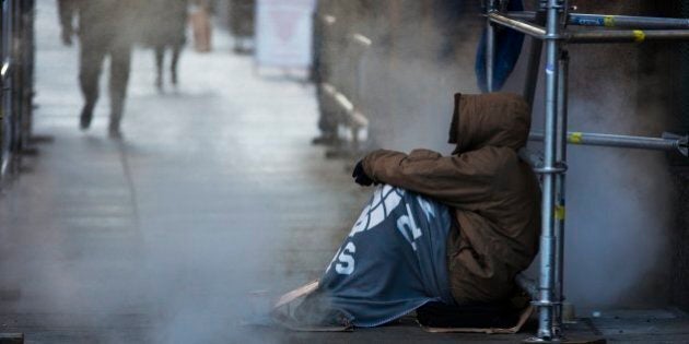 TORONTO, ON - JANUARY 4: A homeless man tries to keep warm near a steam vent in the bone chilling winter temperatures of -13 in downtown Toronto, Ontario. (Todd Korol/Toronto Star via Getty Images)