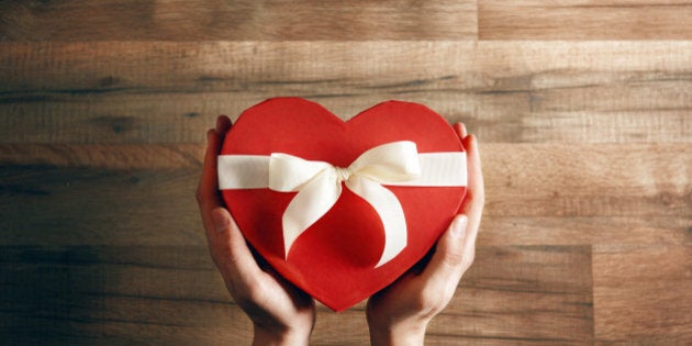 male hands holding a gift in the shape of a heart. the concept of love and Valentine's day