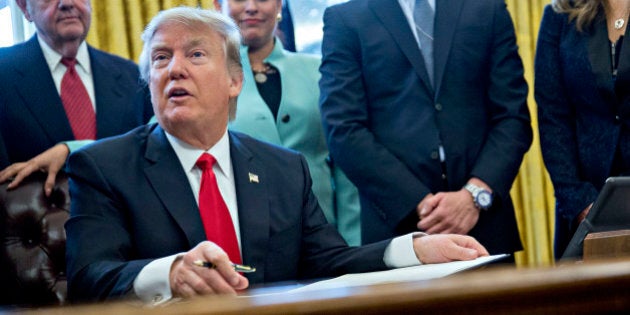 WASHINGTON, DC - JANUARY 30: (AFP OUT) U.S. President Donald Trump speaks before signing an executive order surrounded by small business leaders in the Oval Office of the White House January 30, 2017 in Washington, DC. Trump said he will 'dramatically' reduce regulations overall with this executive action as it requires that for every new federal regulation implemented, two must be rescinded. (Photo by Andrew Harrer - Pool/Getty Images)