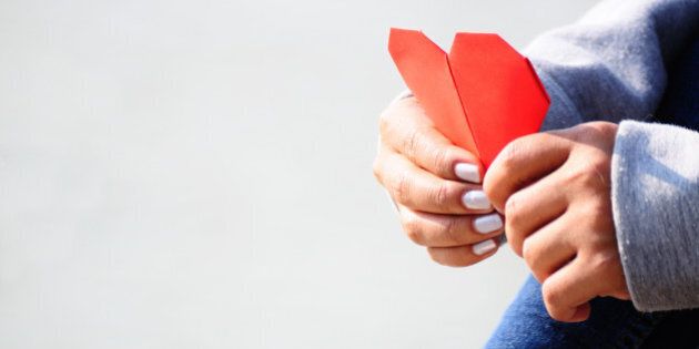 Hands Holding a Red Heart Shape Paper