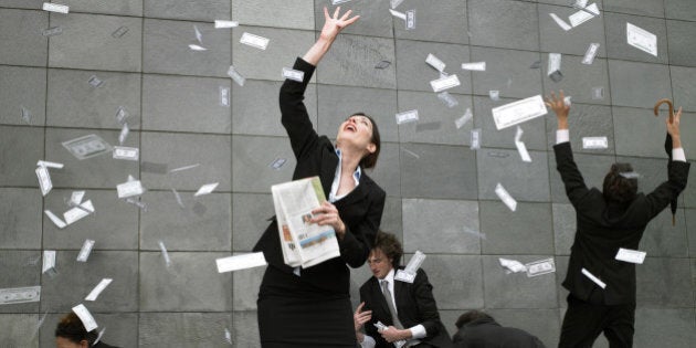 Business people on pavement catching falling money