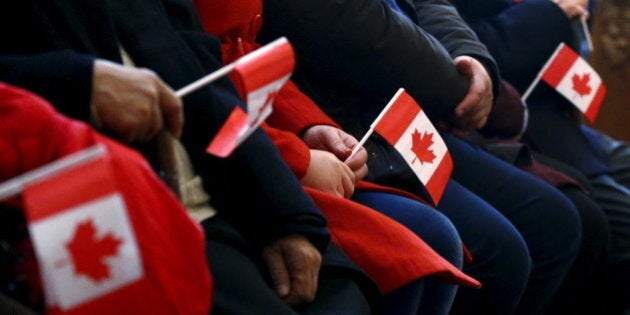 Syrian refugees hold Canadian flags as they take part in a welcome service at the St. Mary Armenian Apostolic Church at the Armenian Community Centre of Toronto in Toronto, December 11, 2015. REUTERS/Mark Blinch