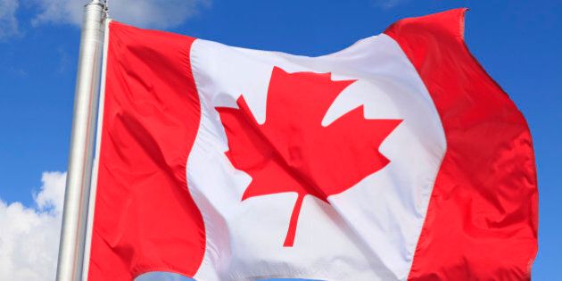 Canadian flag waving on the wind with blue sky and white clouds on the background, Quebec, Canada