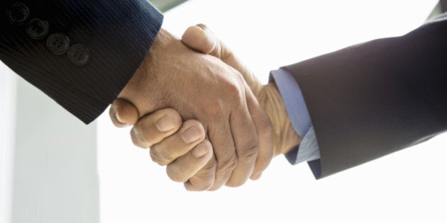 businesmen shaking hands in conference room