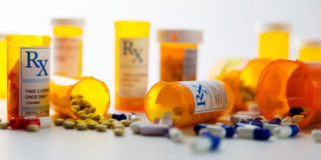 Prescription bottles and pills on a counter.