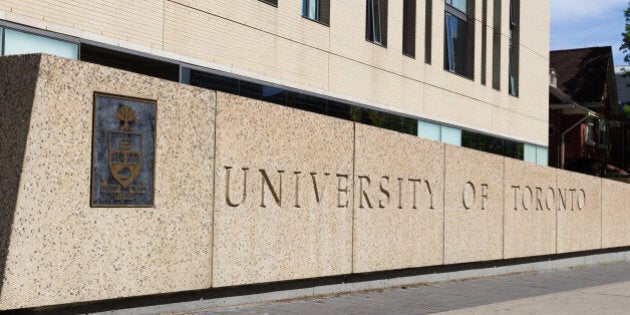 Toronto, Canada - May 31, 2014: A sign for the University of Toronto. Buildings can be seen in the background