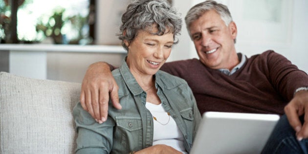 Shot of a mature couple using a digital tablet while relaxing on their sofa