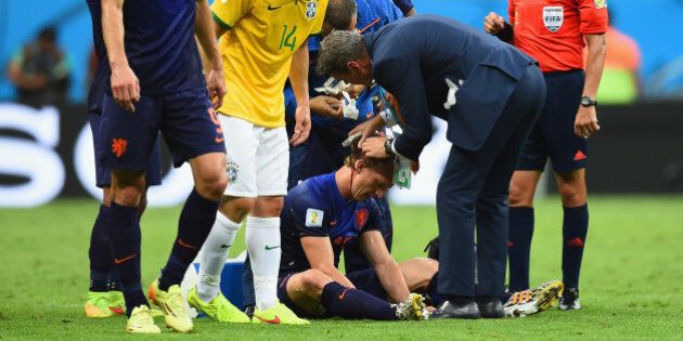 BRASILIA, DF - JULY 12: Dirk Kuyt of the Netherlands receives treatment after a clash as Maxwell of Brazil stands over during the 2014 FIFA World Cup Brazil Third Place Playoff match between Brazil and the Netherlands at Estadio Nacional on July 12, 2014 in Brasilia, Brazil. (Photo by Buda Mendes/Getty Images)